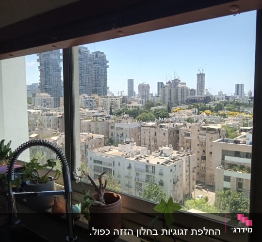 נוף עירוני מבעד לחלון עם מסגרת אלומיניום